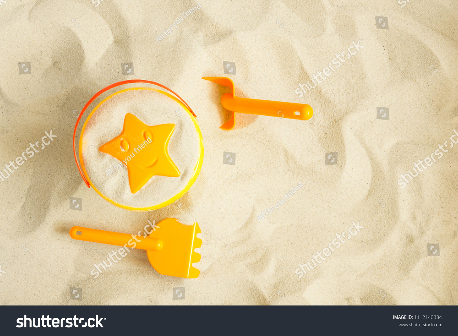 Bright plastic children's toys in the sand. Concept of beach recreation for children. Top view. Space for text. Flat lay top view copy space
