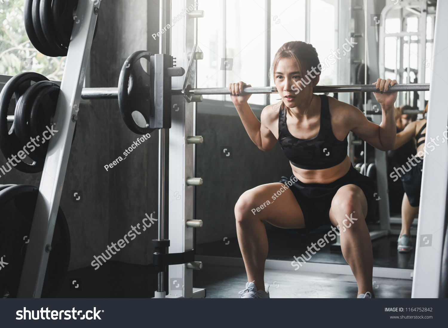 Fitness asian woman doing exercise and lifting barbell weights in sport gym healthy lifestyle concept