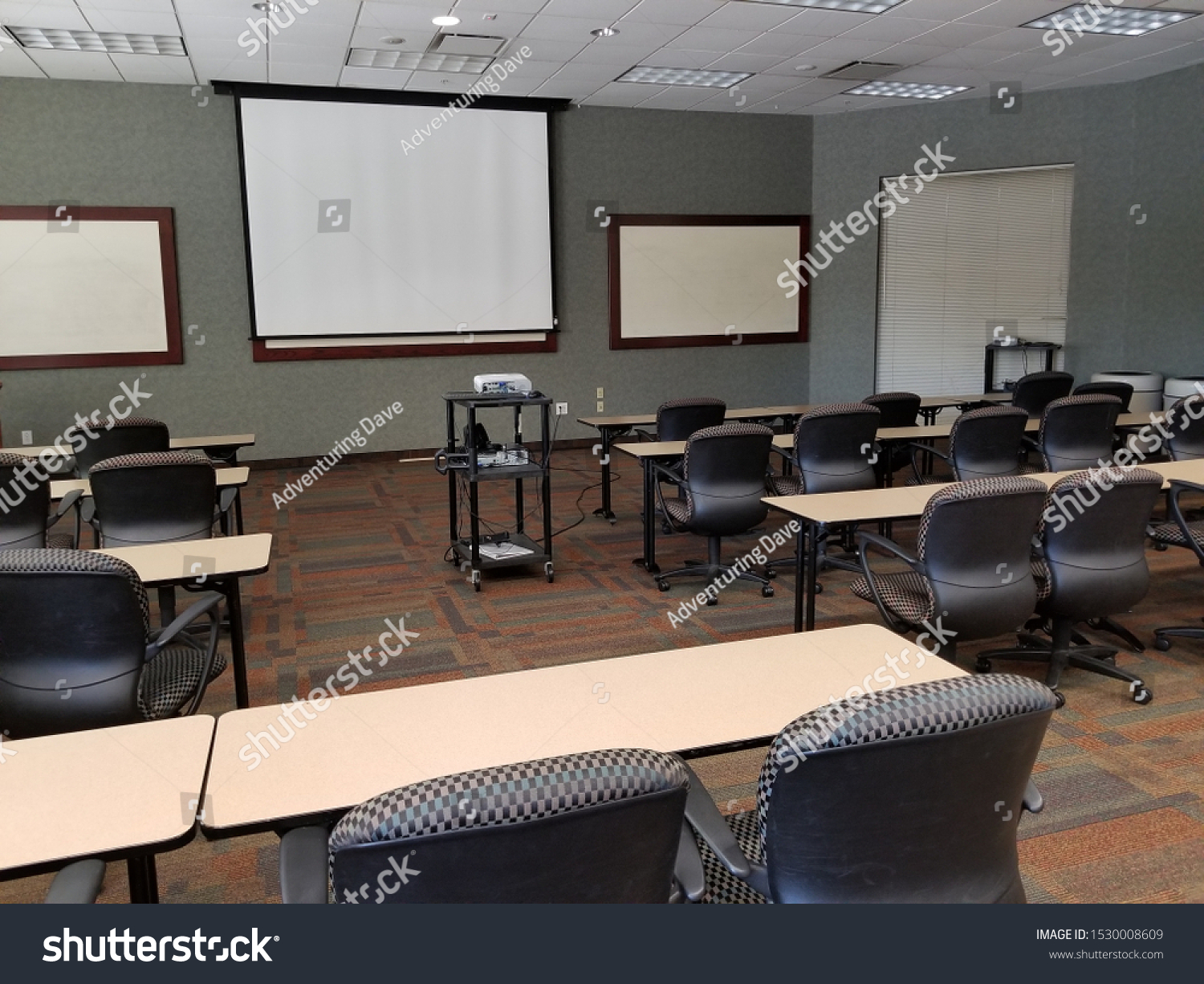 View to front of classroom with computer projector and projection screen for education technology