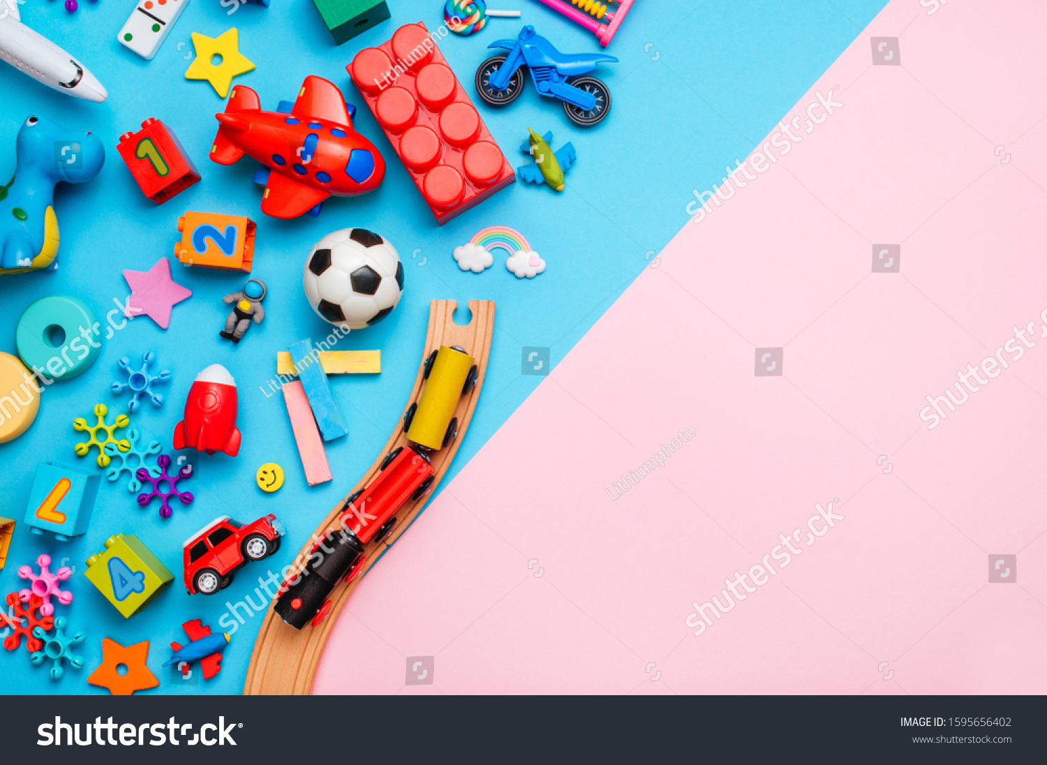 Frame of kids toys on color block pink and blue background with blank space for text. Top view flat lay.