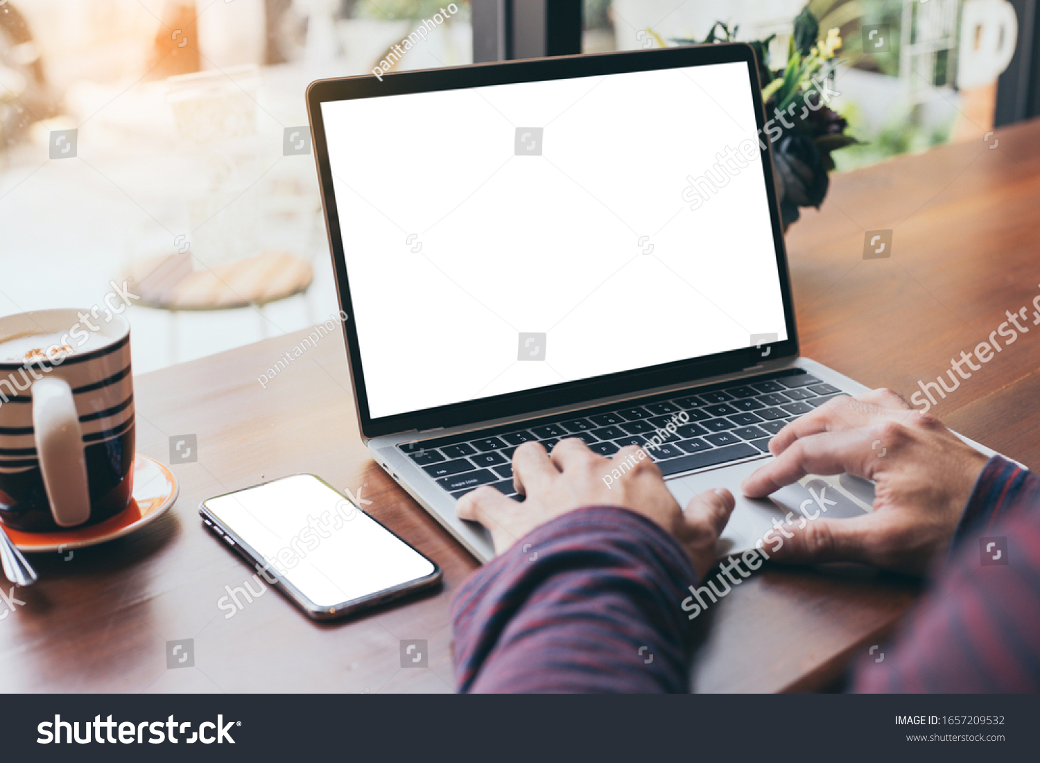 computer cell phone mockup image blank screen with white background for advertising text hand man using laptop texting mobile contact business search information on desk in cafe.marketing design