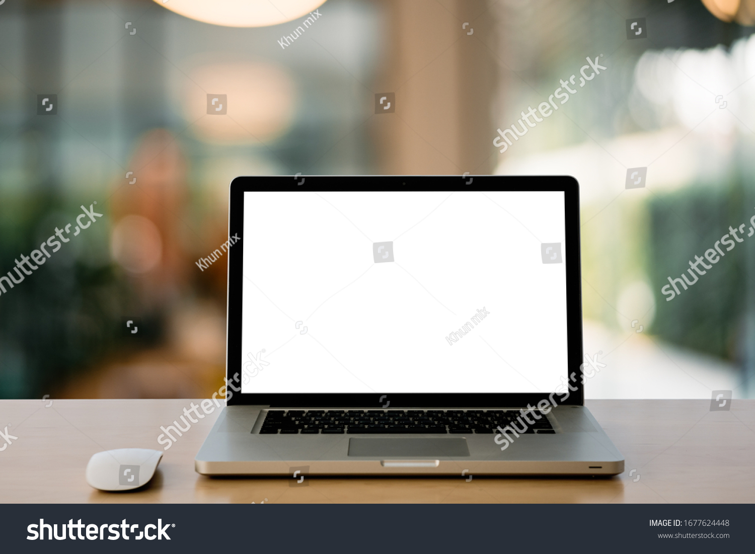 Empty space Wooden Computer Desk and Laptop with blank screen and wireless mouse in office with modern blurred background light bokeh.- Image