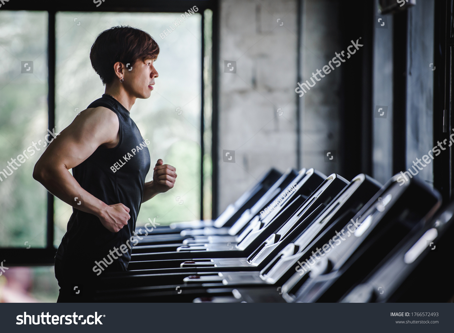 Handsome Asian men are exercising in sportswear and jogging on the treadmill at the gym. Electric treadmill in the fitness center