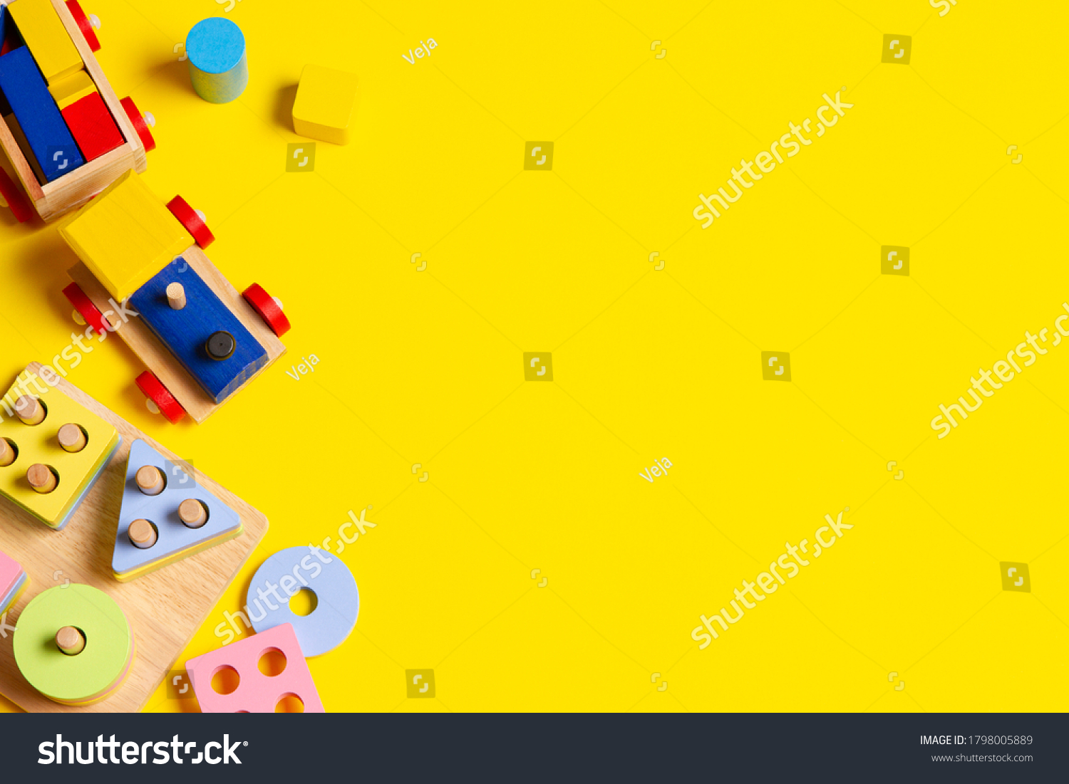 Baby kids toys background. Wooden train educational stacking color recognition puzzle toy and colorful blocks on yellow background. Top view