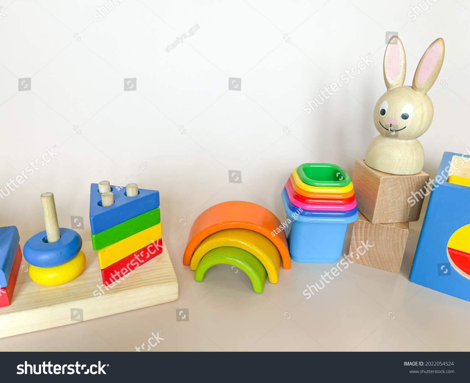 Wooden toys on a light background. The concept of child development according to the Montessori method. A colored rainbow. Previously the development. Eco-friendly toys.