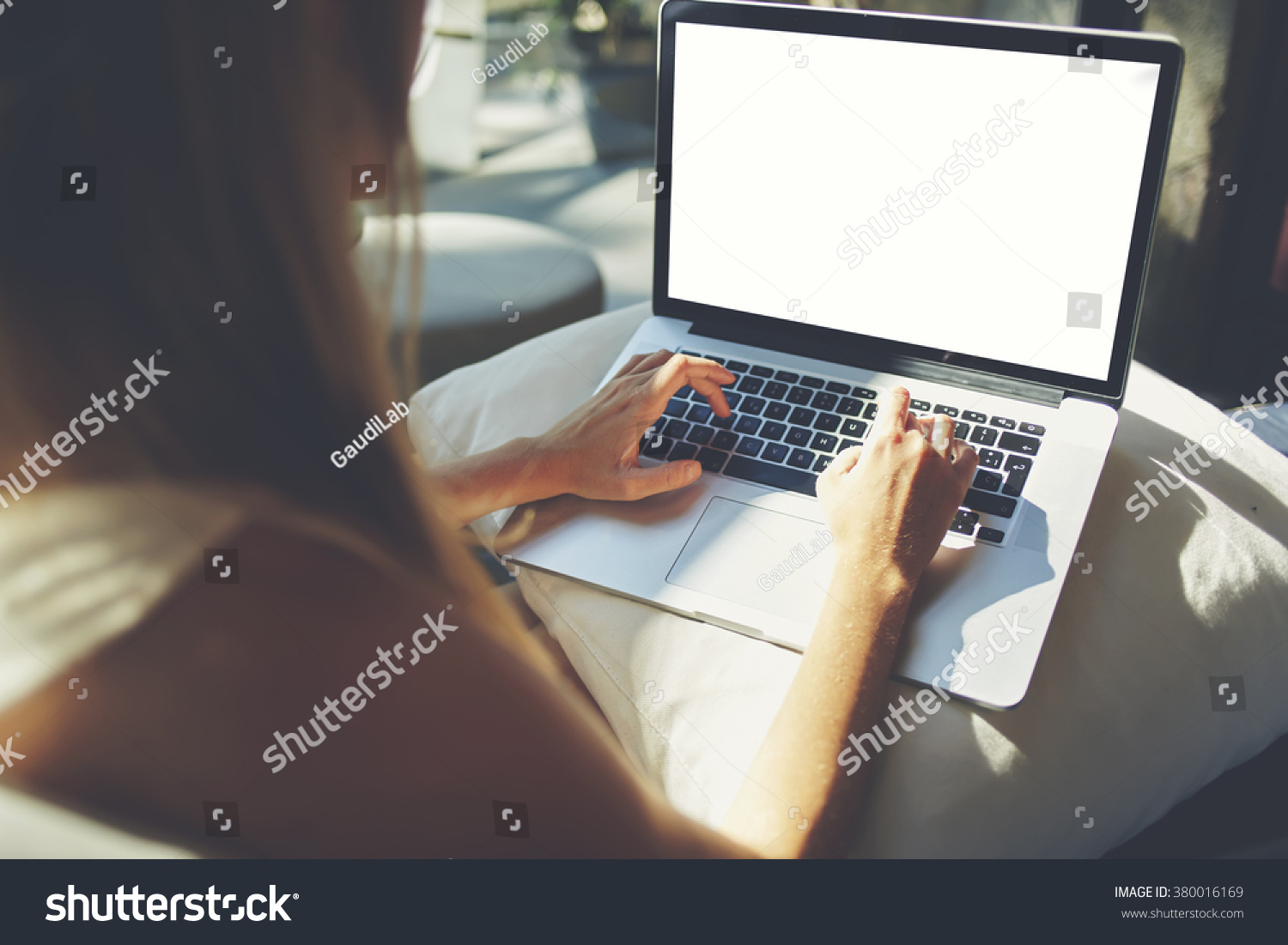 Back view of woman freelancer is working on a new project on laptop computer with blank copy space screen for your advertising text message hipster girl keyboarding on net-book while relaxing at home