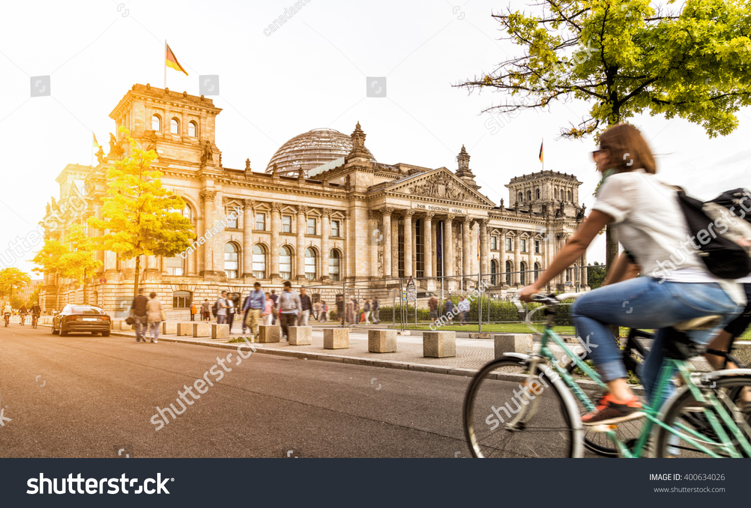 Urban city life with famous Reichstag building in the background in beautiful golden evening light at sunset in summer with retro vintage Instagram style pastel toned filter effect Berlin Germany
