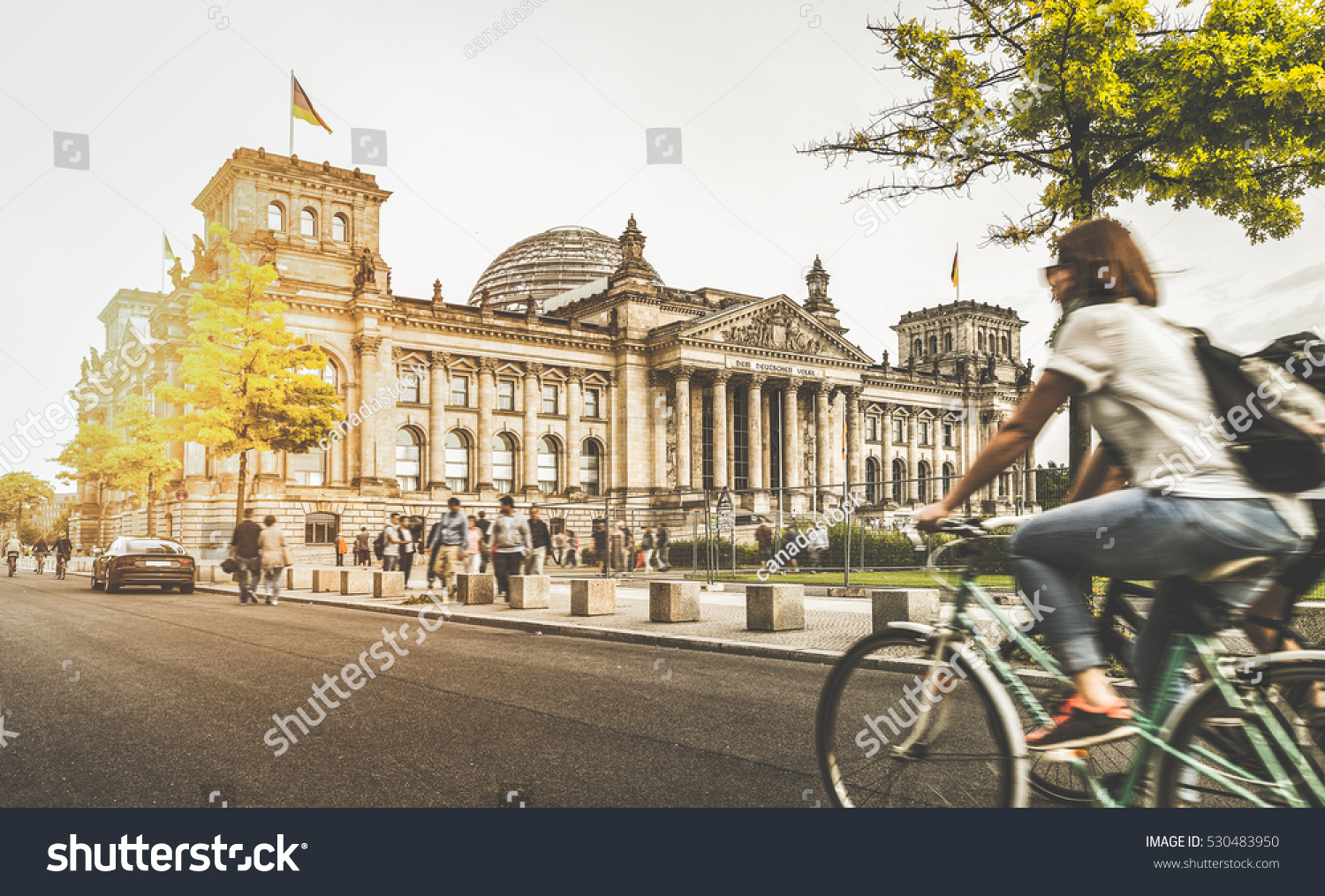 Berlin urban city life with famous Reichstag building in the background in beautiful golden evening light at sunset in summer with retro vintage Instagram style pastel toned filter effect Germany