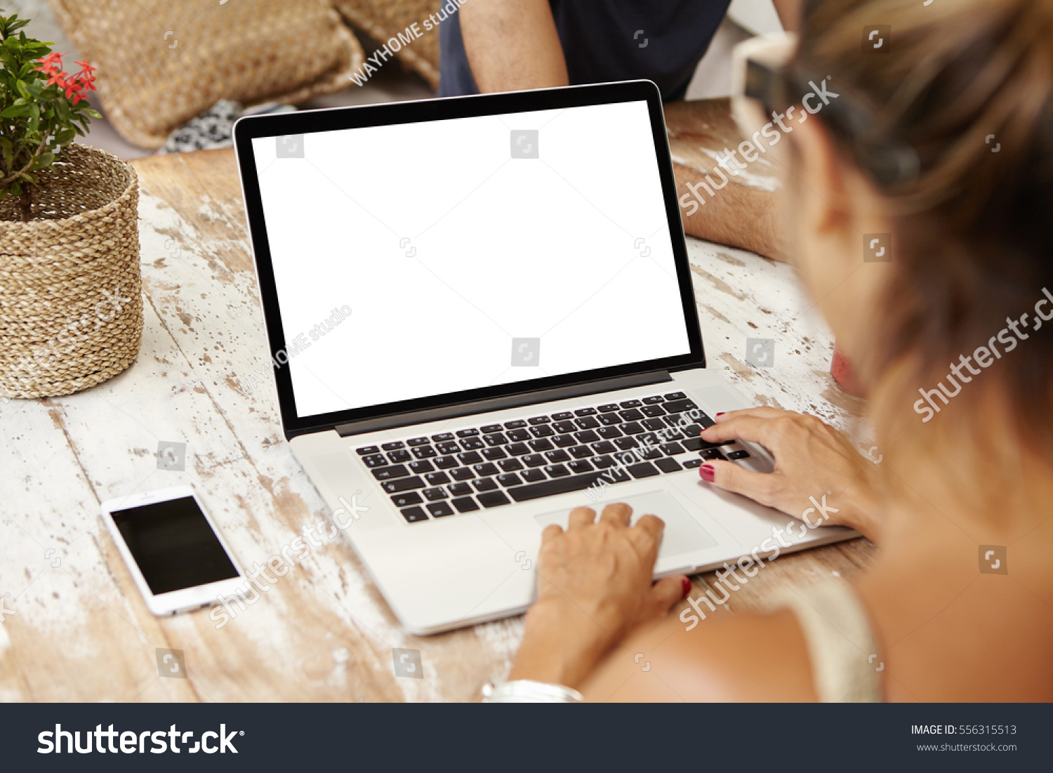 People lifestyle modern technology and communication concept. Young Caucasian female writer keyboarding on laptop while working on her new article for online women's magazine. View form back