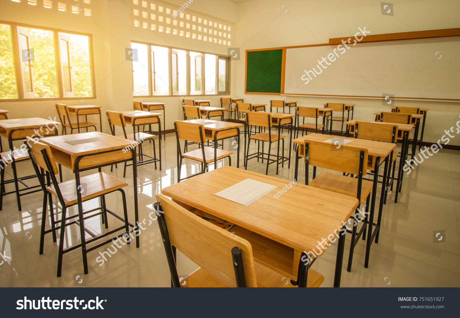 School empty classroom with test sheet or exams paper on desks chair wood and greenboard at high school thailand education test concept
