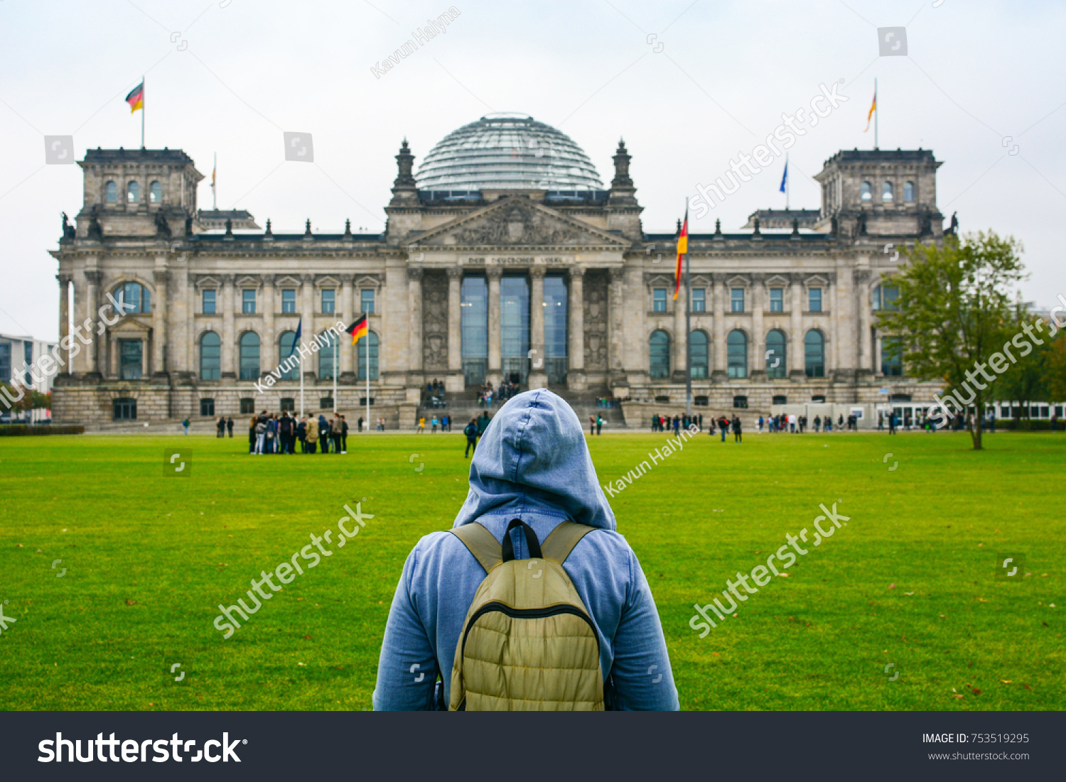 Young woman with backpack looking at Bundestag building in Berlin. Erasmus student studying abroad and tourist concept.