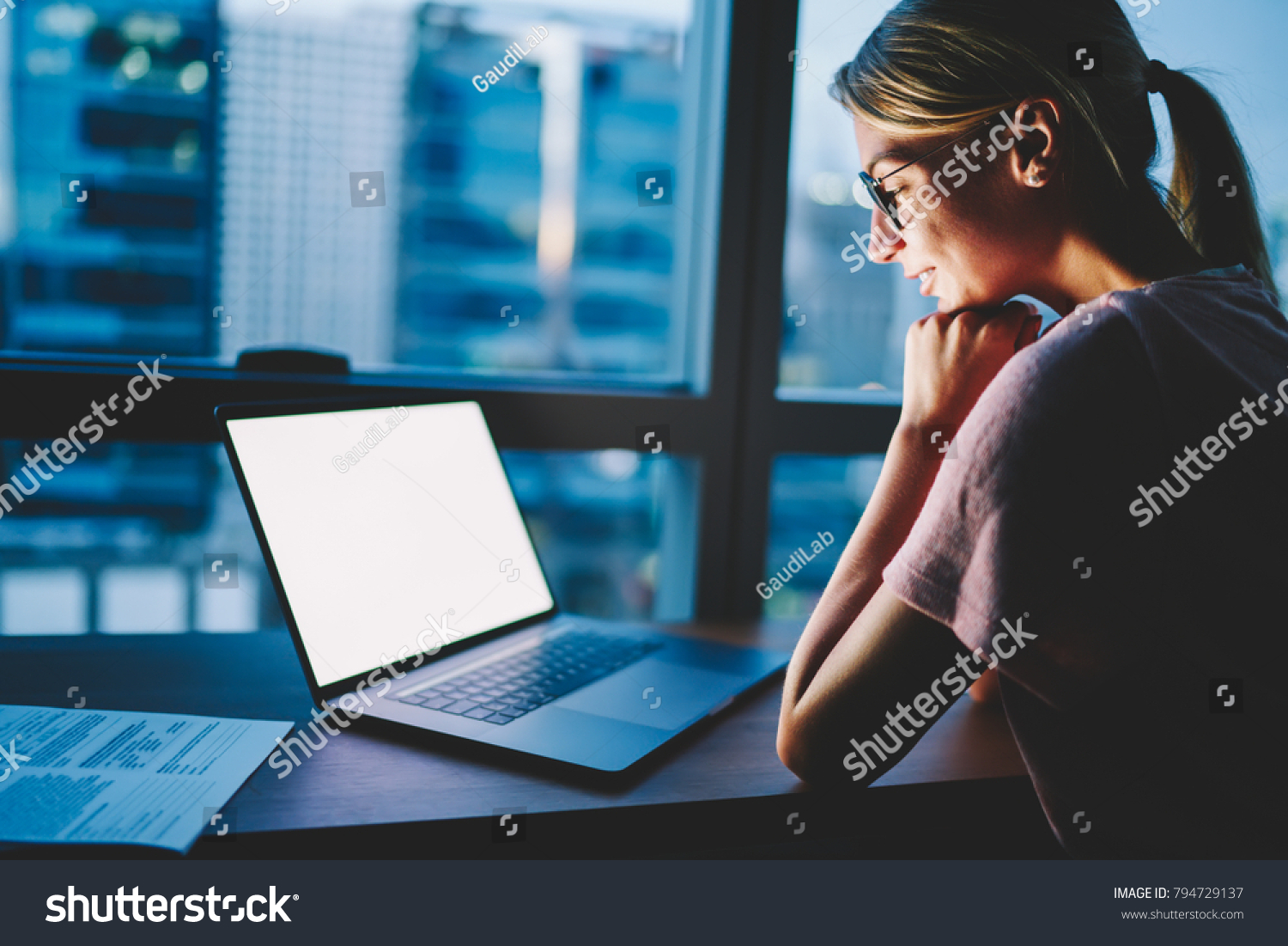 Smiling female designer in eyewear satisfied with watching your advertising on blank copy space screen on laptop computer spending evening time at home. Woman reading mock up content on modern netbook