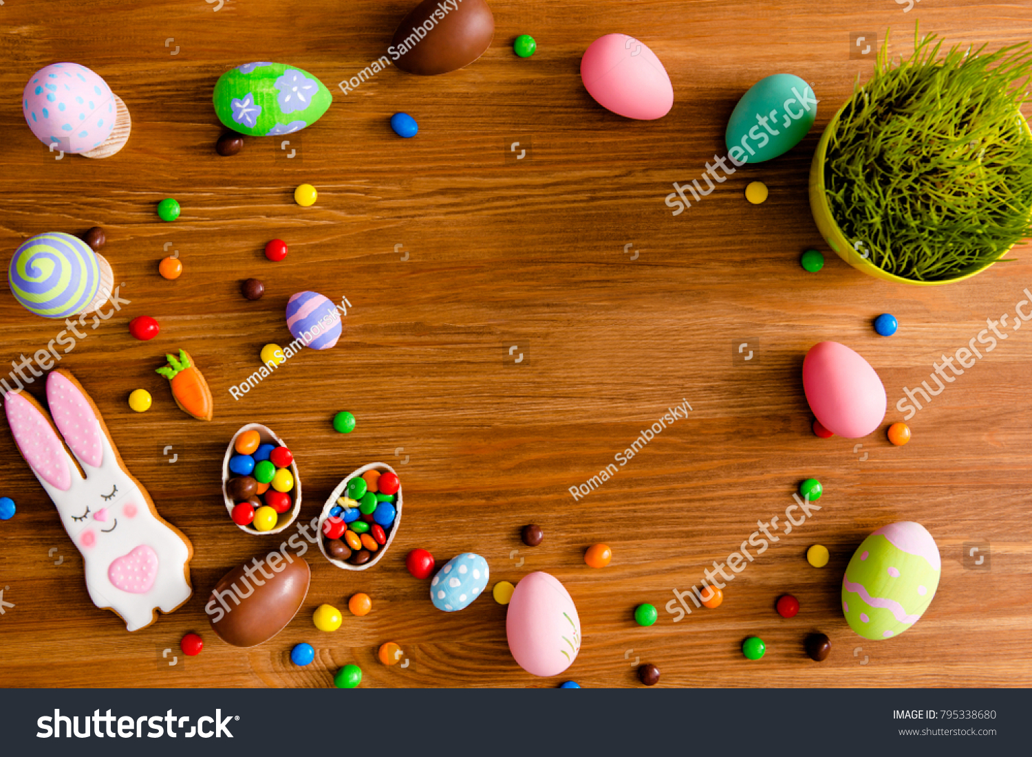 Top view portrait with copy space for text of easter objects on wooden brown background laying painted eggs flower baked cookies in carrot and hare figure