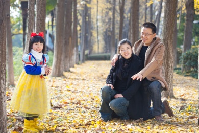 幸福的家庭和睦肖像在森林里，父亲，母亲和女儿。