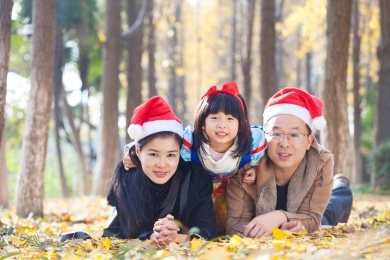 幸福的家庭和睦肖像在森林里，父亲，母亲和女儿。