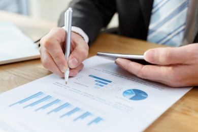 检查商人利用计算机，键盘和mobilephone表上的财务报告