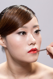 在白色背景上的年轻亚裔美丽的女人的面部化妆