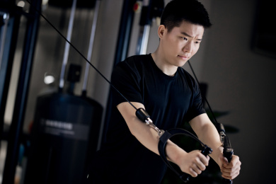 一名年轻男性在健身房做拉伸运动