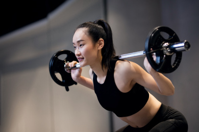 一年轻女性在健身房举杠铃