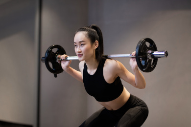 一年轻女性在健身房举杠铃