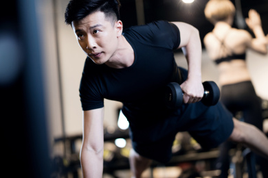 一名男子在健身房进行力量训练
