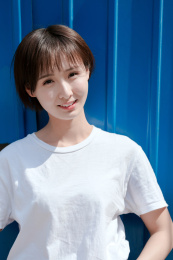 一位年轻女孩站在蓝色背景墙前