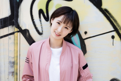 一位年轻女孩站在涂鸦墙前