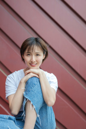 在红色背景墙前的女孩