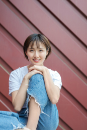 在红色背景墙前的女孩