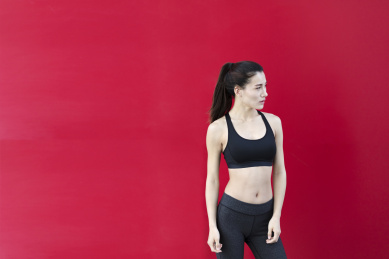 一名运动女生站在红色背景前