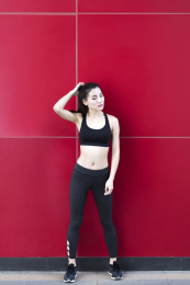 一名运动女生站在红色背景前