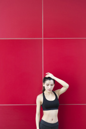 一名运动女生站在红色背景前