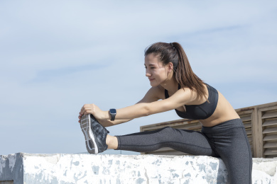 年轻女子在蓝天下跑步锻炼