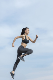 年轻女子在蓝天下跑步锻炼