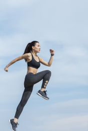 年轻女子在蓝天下跑步锻炼