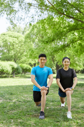 年轻女子在教练的指导下做拉伸运动
