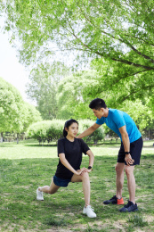 年轻女子在教练的指导下做拉伸运动