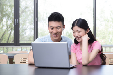 年轻夫妇在库中使用笔记本电脑