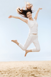 快乐的年轻女性在海边跳跃