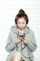 年轻女生使用耳机听音乐