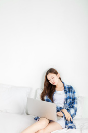 亚洲女生在卧室里使用电脑