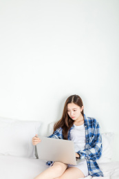 亚洲女生在卧室里使用电脑