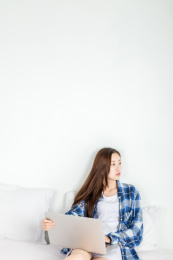 亚洲女生在卧室里使用电脑