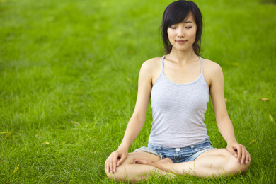 草原上的一个年轻漂亮的亚洲女人实践的研究瑜伽