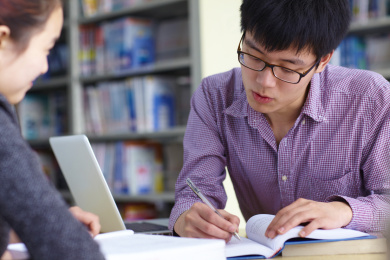 两个年轻的亚洲大学生在图书馆学习