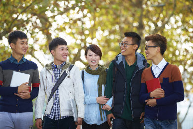 快乐的亚洲大学生在校园里走在一起