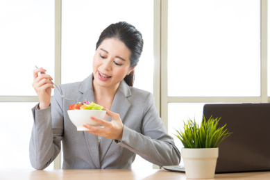 年轻的亚裔商人享受办公室健康沙拉