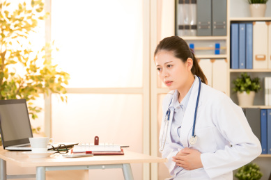 美丽的年轻女子坐在她的肚子手牵着手。混血亚洲的中国模式。医疗保健概念。