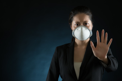 女商人戴口罩，以应对病毒或污染。示出不同于手势的手。年轻多种族亚洲中国女模特