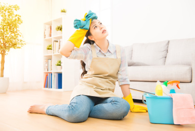 女人家庭主妇感到疲倦家里清洗后在客厅坐在木地板。混血亚洲的中国模式。